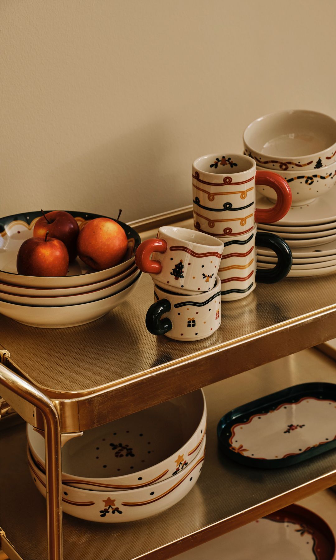 Carrito auxiliar con platos, tazas y bandejas de porcelana blanca con motivos navideños