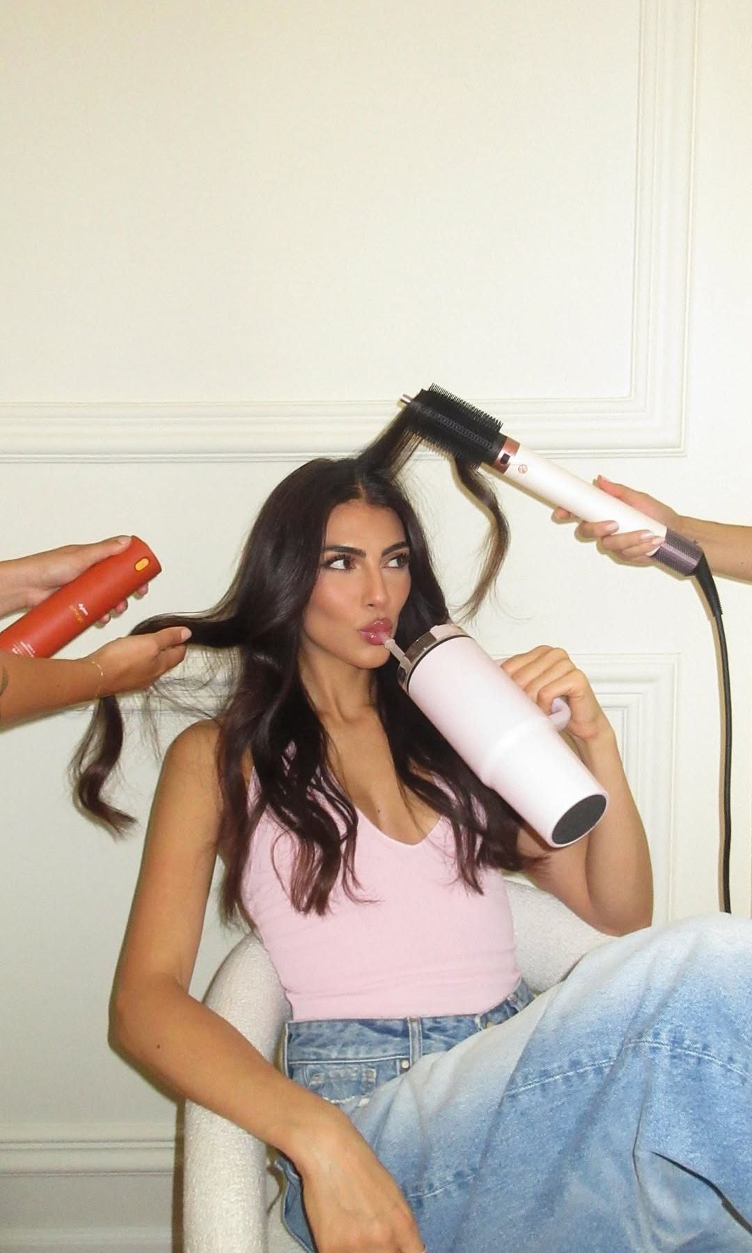 Giulia Salemi bebiendo agua de su termo mientras le arreglan el pelo con cepillo eléctrico