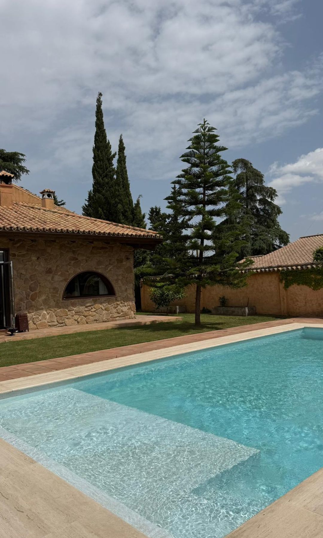La piscina y su solárium se integran con naturalidad en un jardín donde el paisajismo y la arquitectura conviven en perfecta armonía, evocando la serenidad del campo con un diseño actual