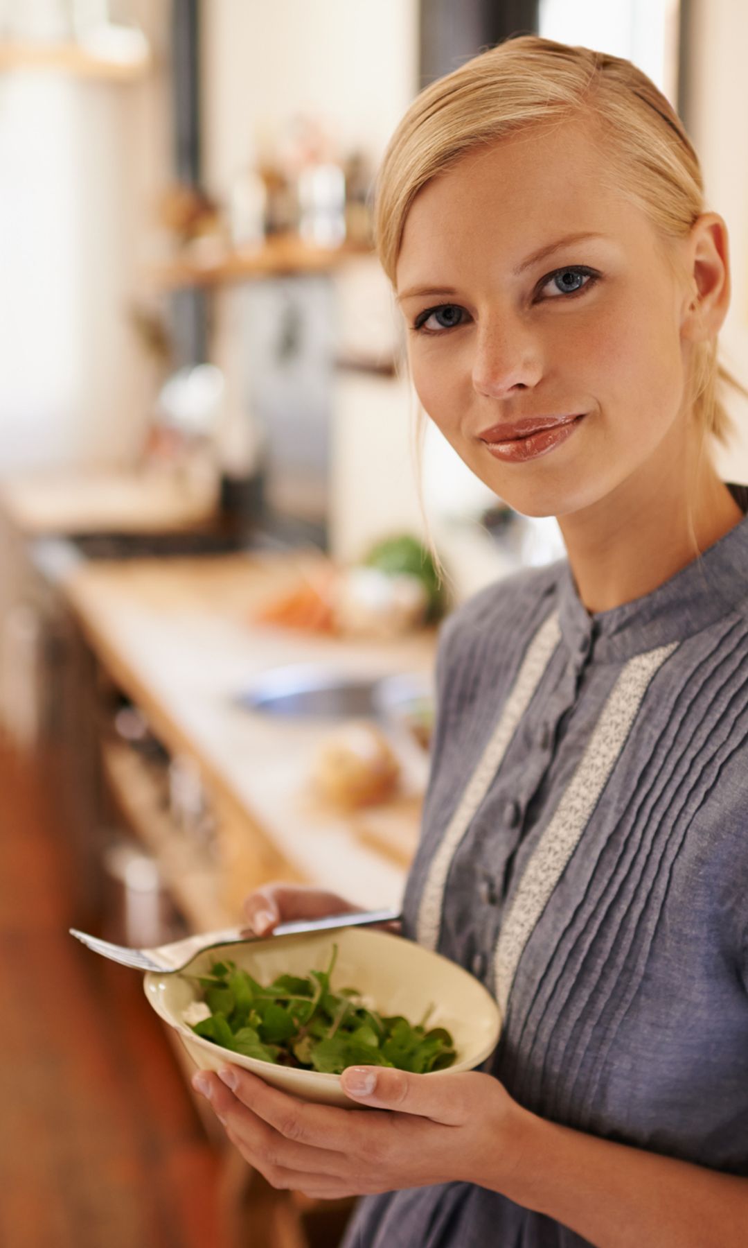 Retrato de mujer en una cocina comiendo saludable