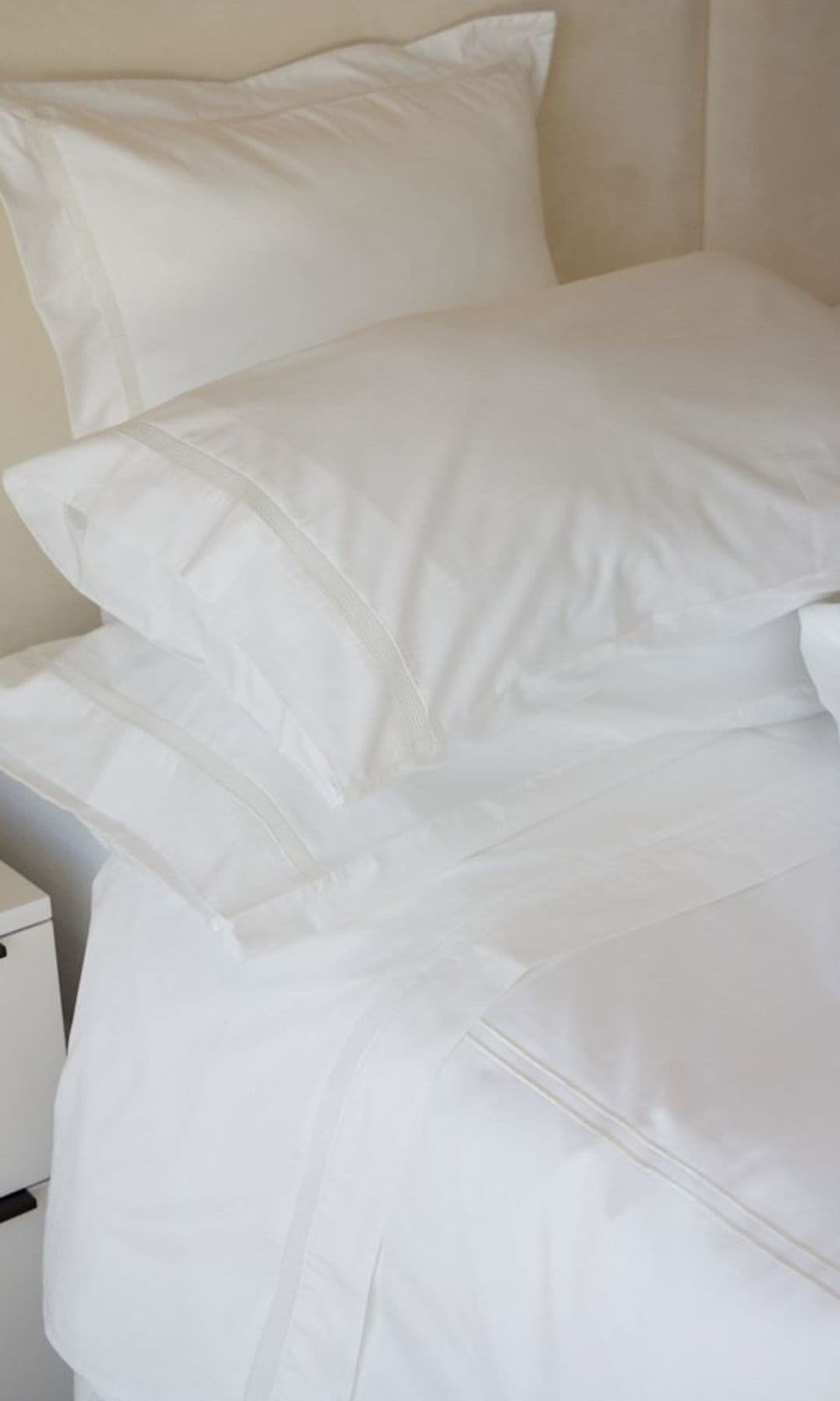 Cama con sábanas de blancas de algodón , almohadas blancas