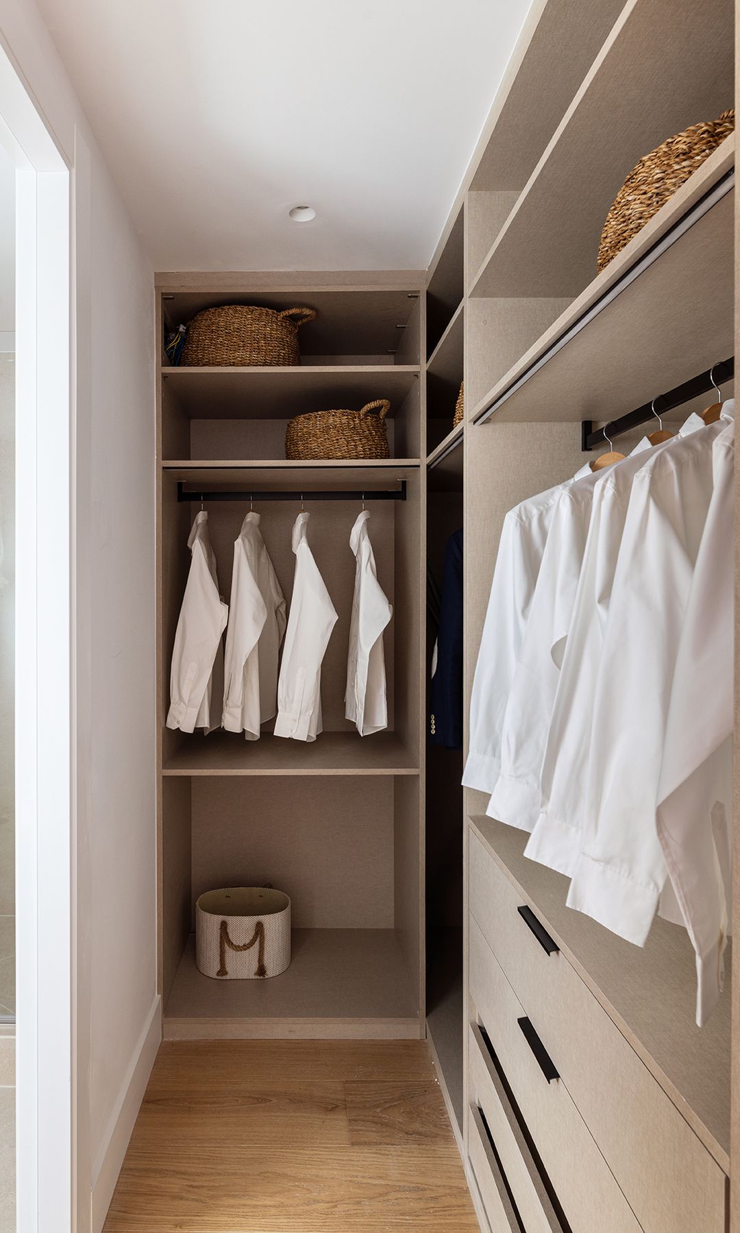 Vestidor con suelo de madera, baldas, cestos y cajoneras 