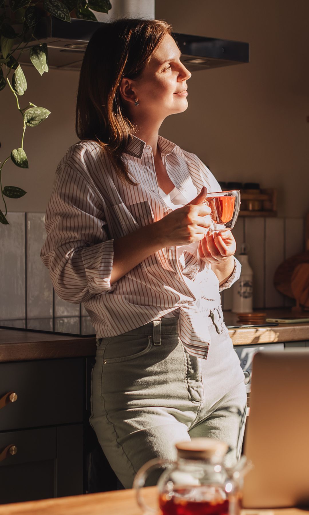 Mujer relajada en la cocina bebiendo té