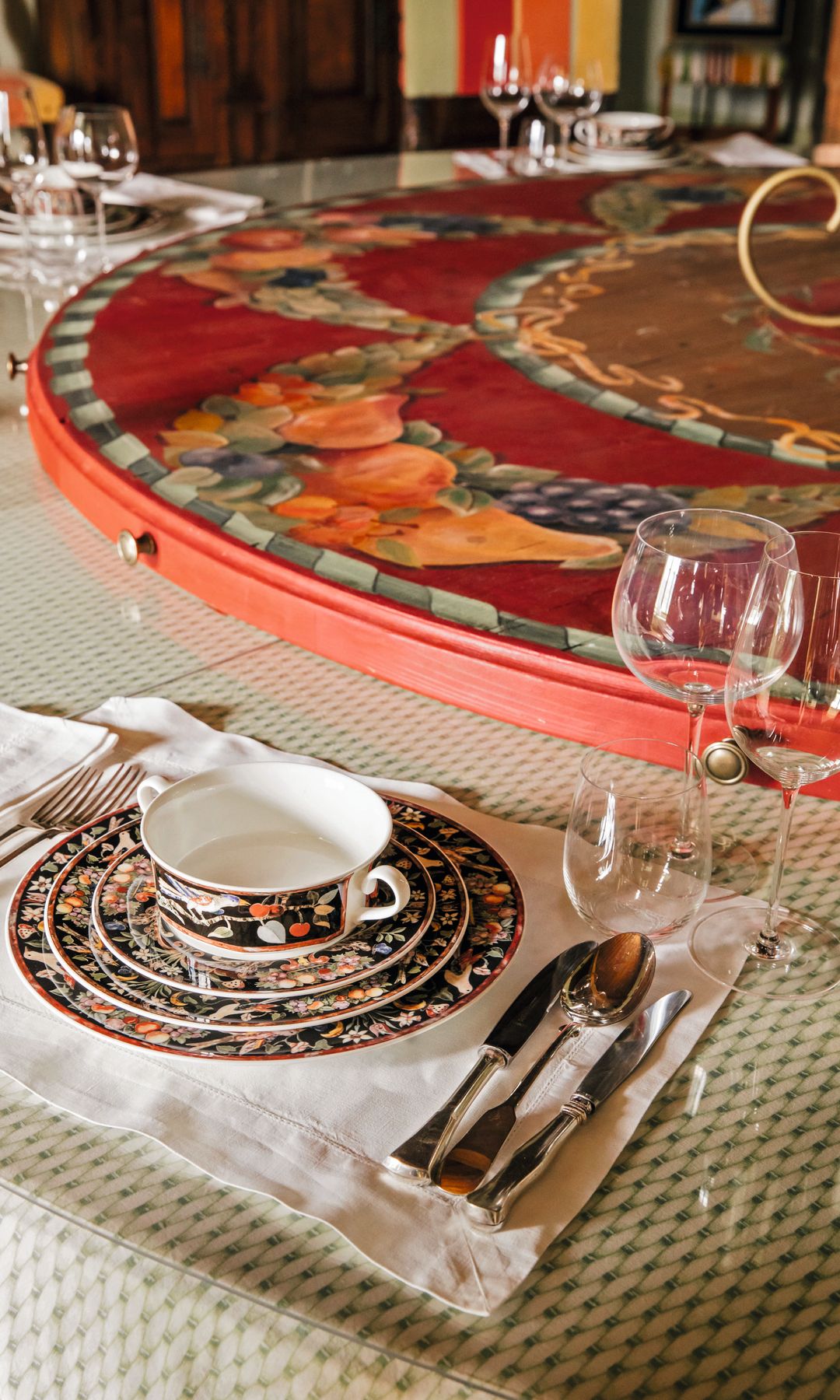 Elegante mesa de comedor con vajilla, cubertería y copas de vino