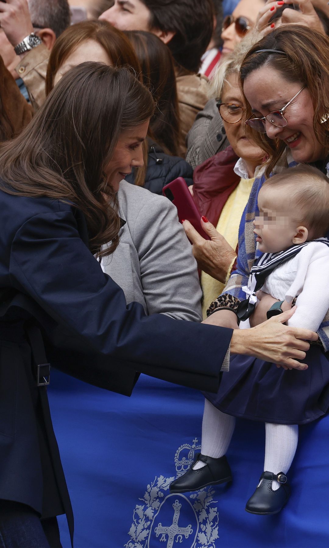 La reina Letizia sorprende con gabardina y el bajo deshilachado de sus vaqueros en su look más cercano y juvenil