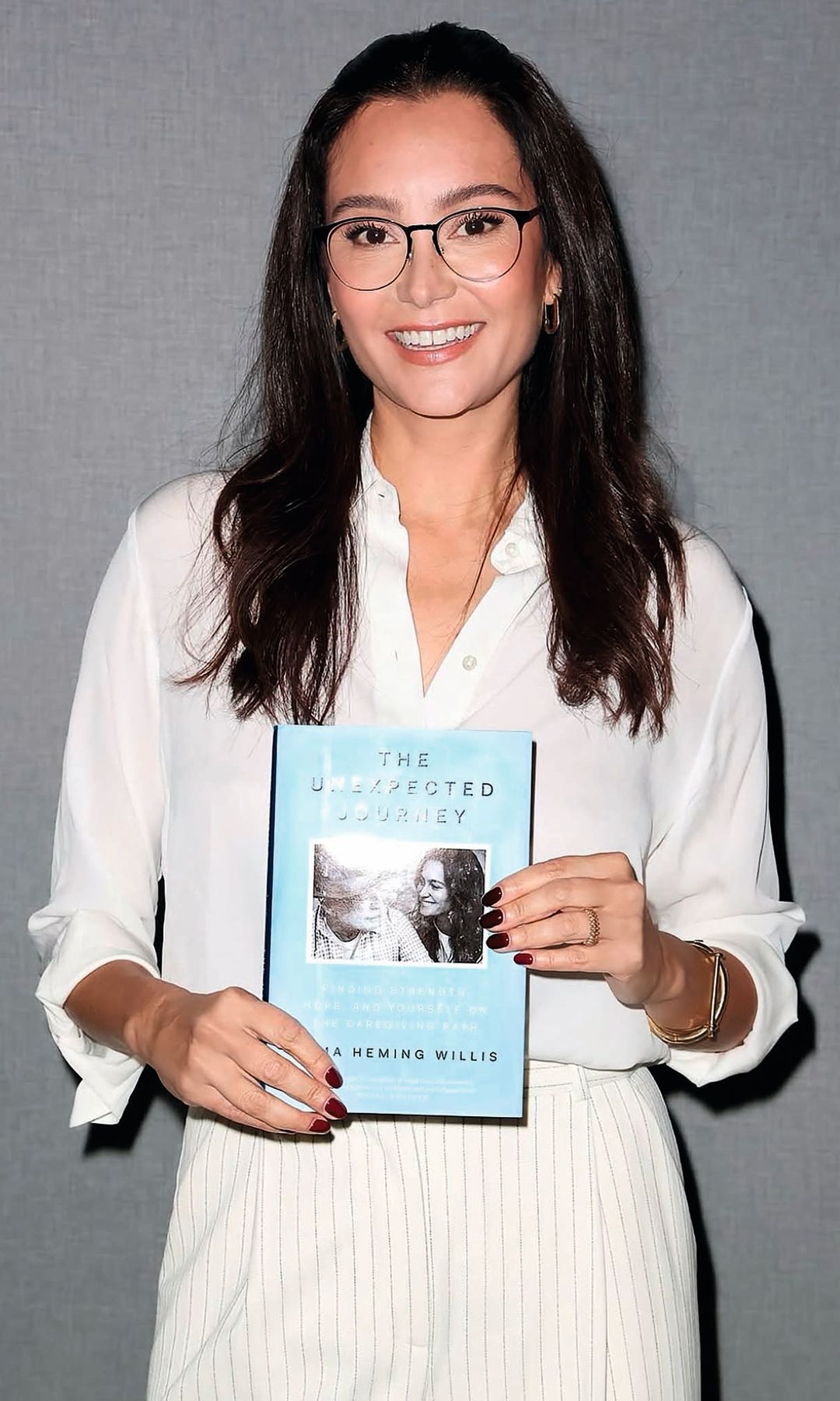 Emma posa con su libro, 'El viaje inesperado: Cuidar de ti misma mientras cuidas a los demás' (Libros Cúpula)