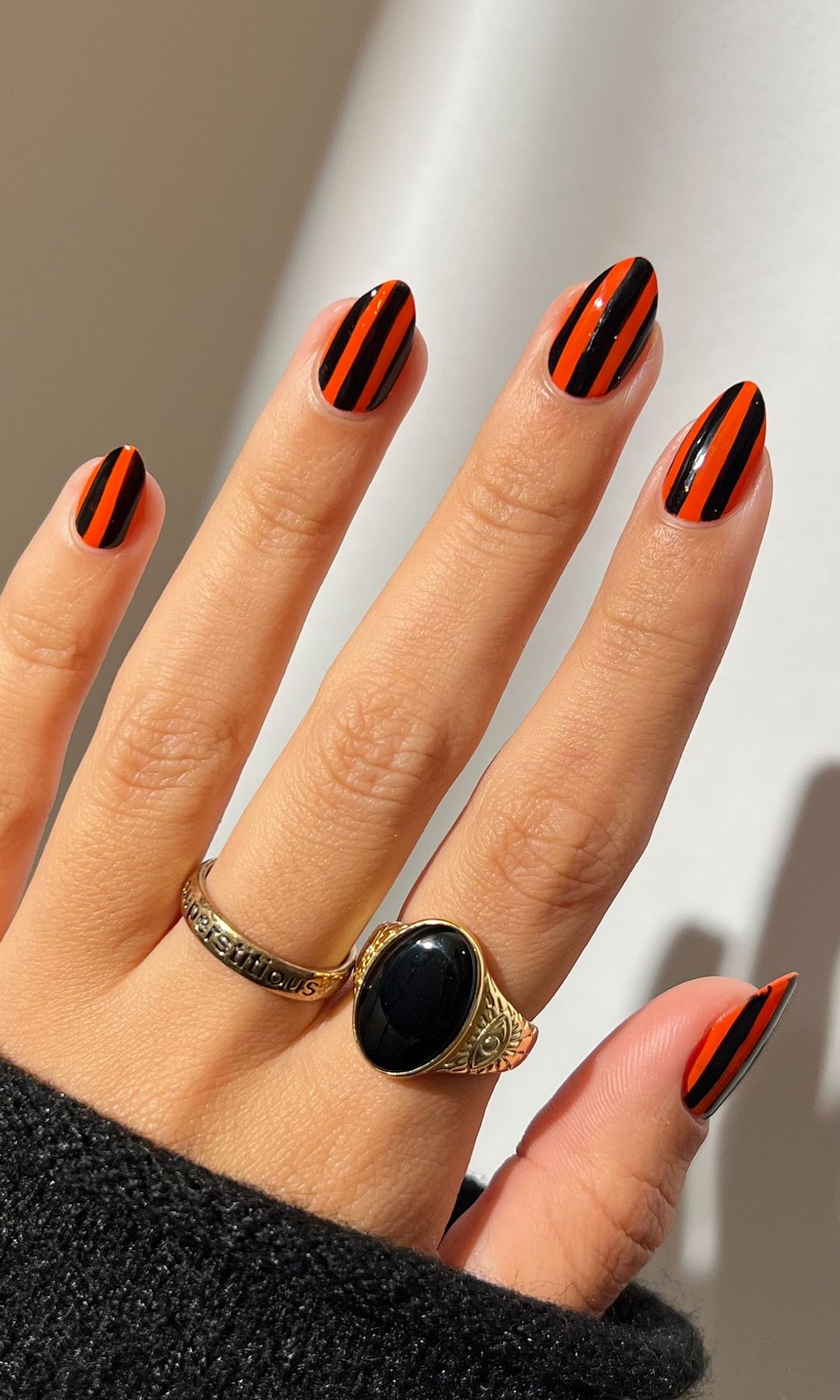 Manicura de rayas negras y naranjas
