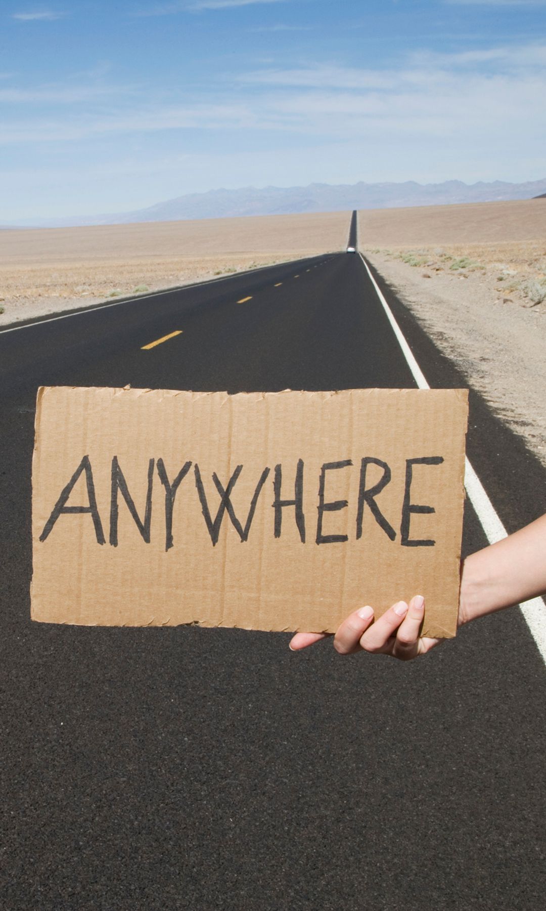 Mujer en la carretera con cartel anywhere