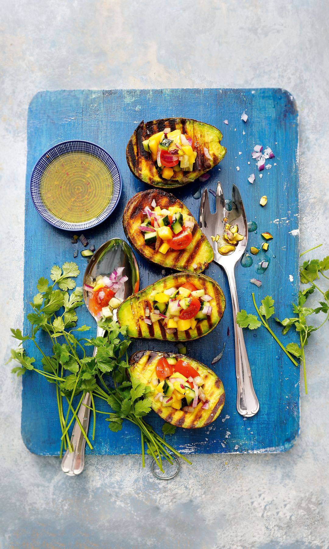 Aguacates a la parrilla con ceviche de verduras, lima y pistachos