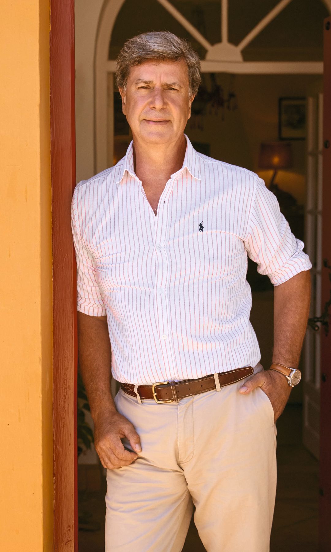 Cayetano Martínez de Irujo, en "Las Arroyuelas" en polo blanco y pantalones beige, apoyado en puerta de madera