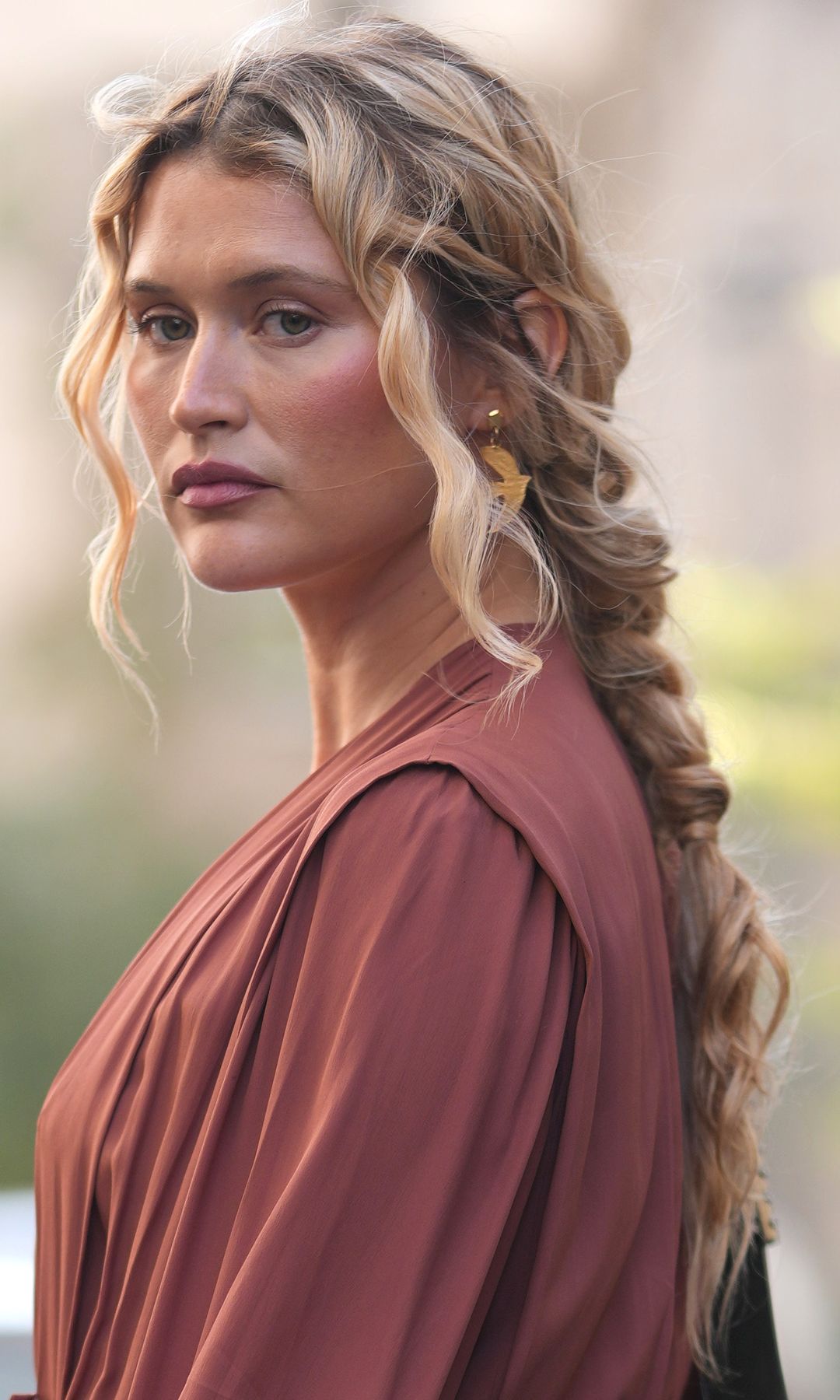 Chloe Lecareux en la Semana de la Moda de Milán con trenza rizada y vestido granate
