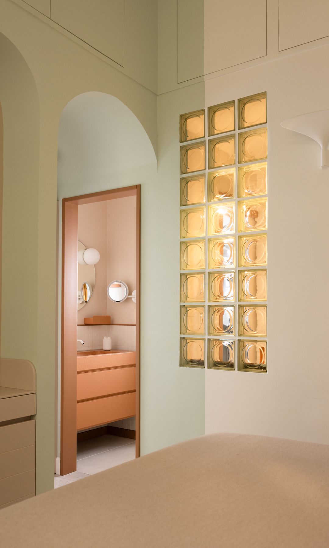 Dormitorio en suite con tabique de pavés entre el baño y el dormitorio