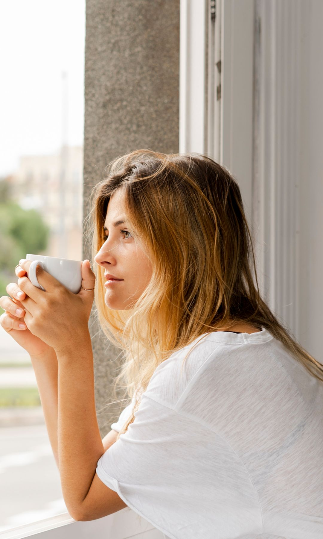 Mujer pensativa en la ventana