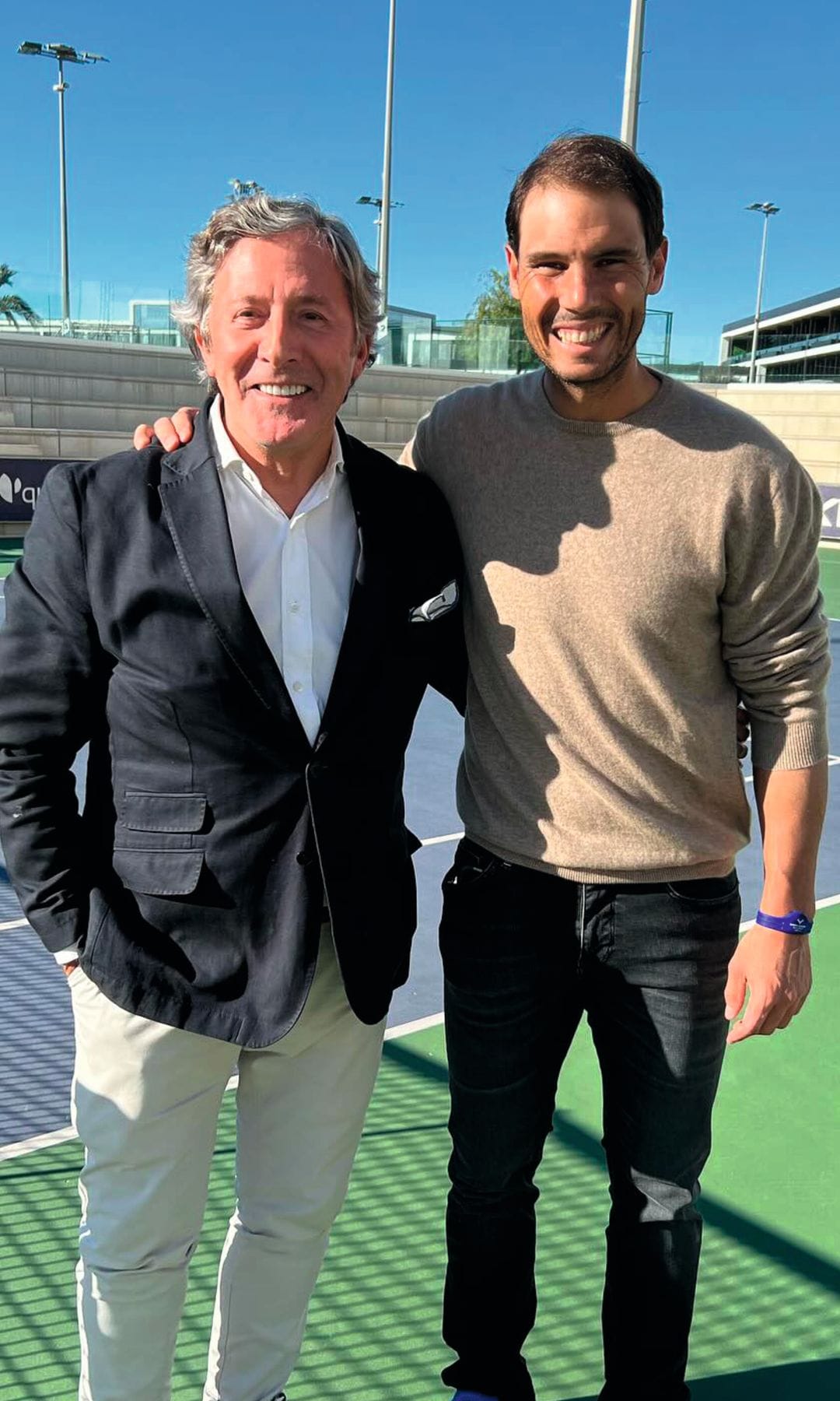 Rafael Nadal junto aJesús Álvarez, ambos sonrientes en una cancha de tenis.