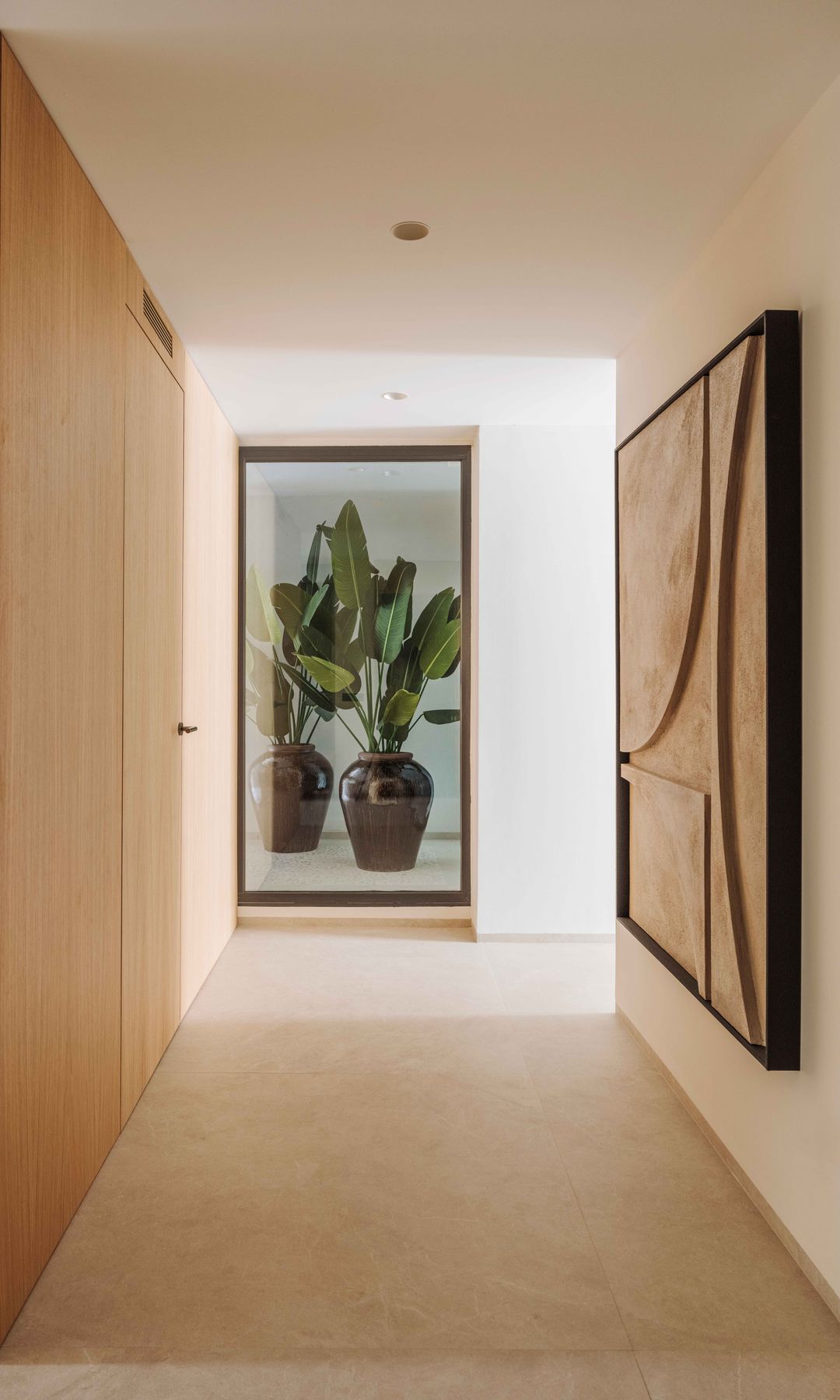 Pasillo con ventanal que da jardín interior, cuadro en la pared, armario de madera