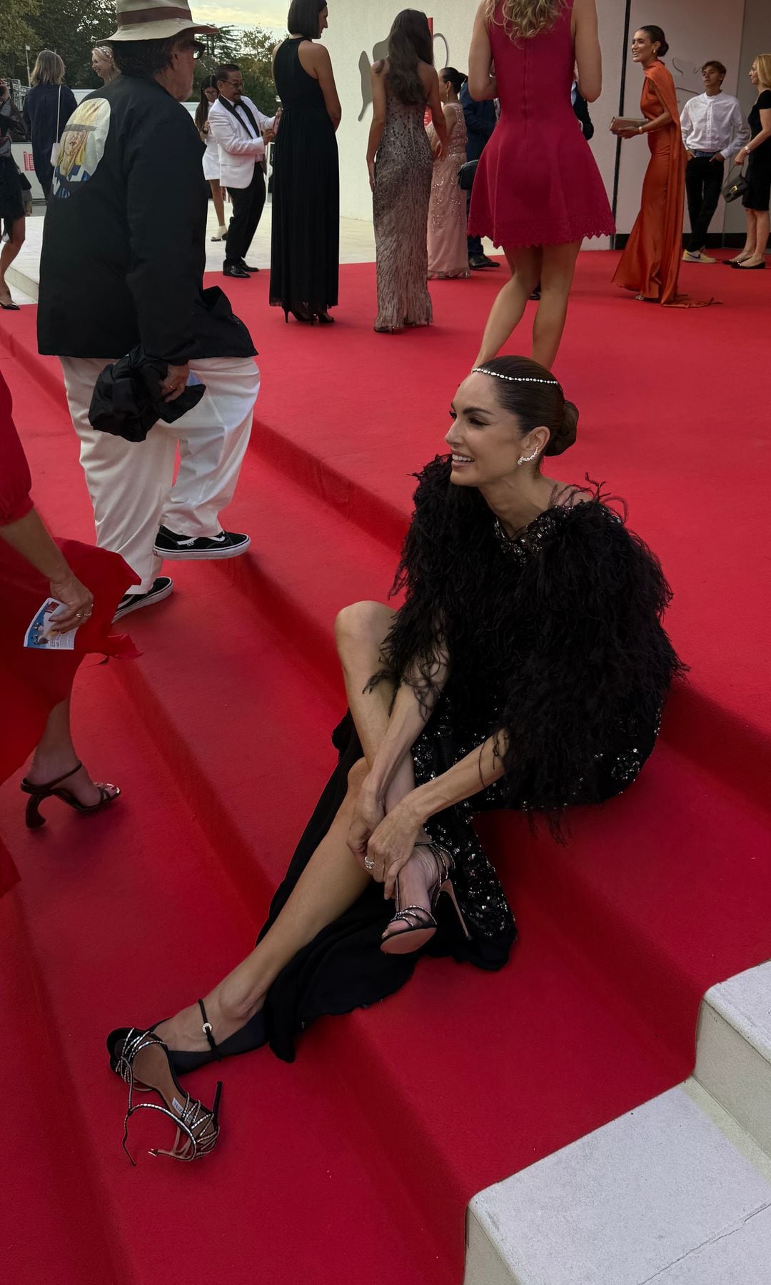 En la alfombra roja del Festival de San Sebastián cambiándose las sandalias de tacón por un zapato plano para estar más cómoda