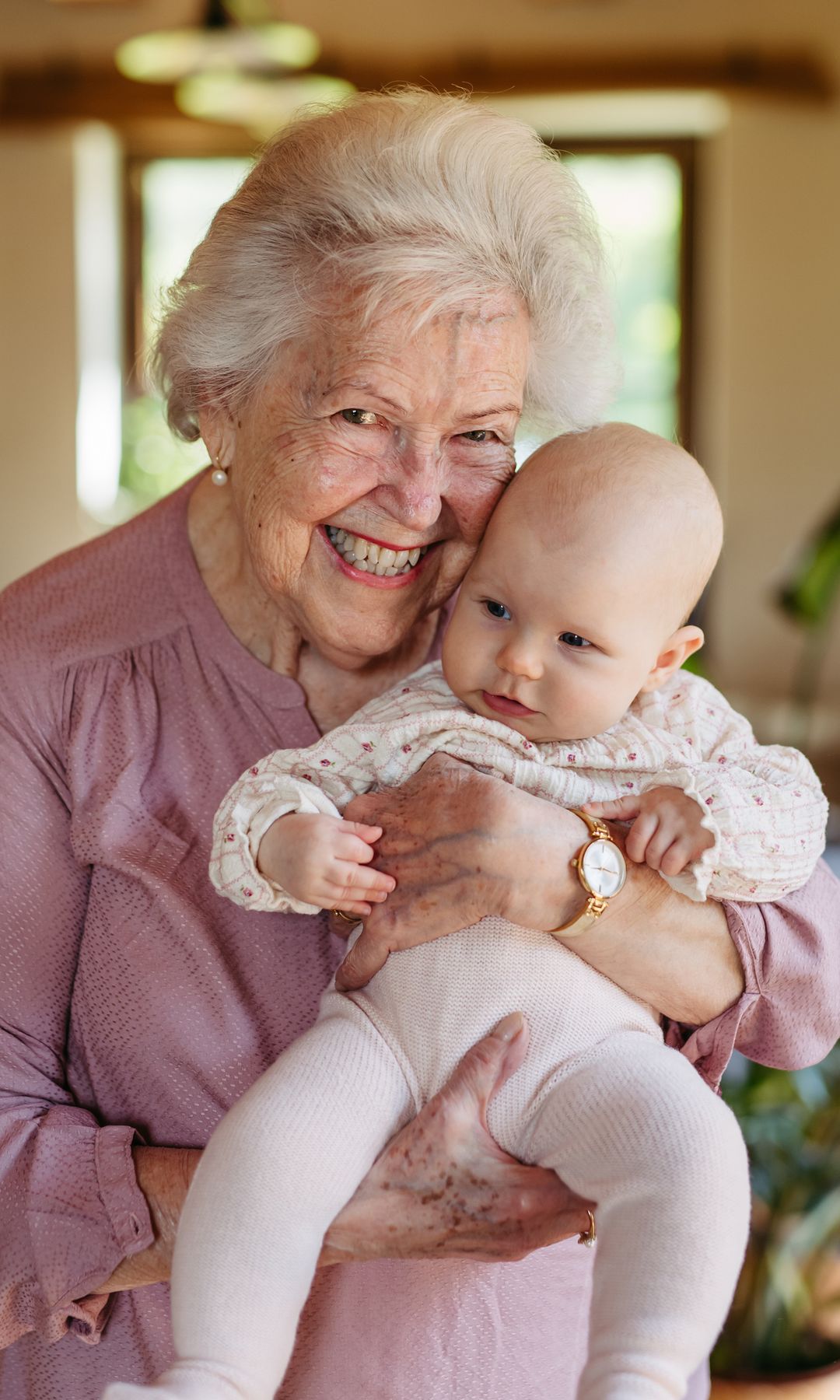 Abuela feliz y muy sonriente con su nieta en brazos