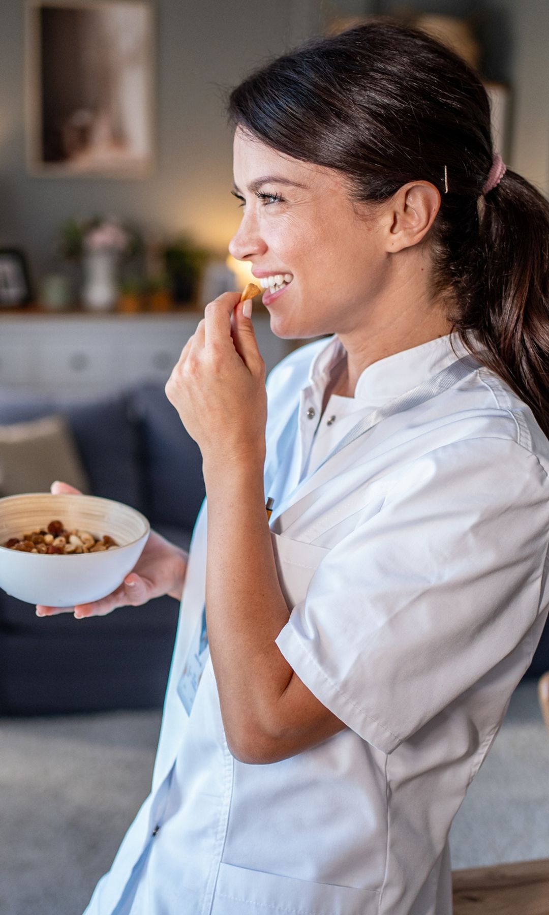 Una mujer feliz comiendo frutos secos