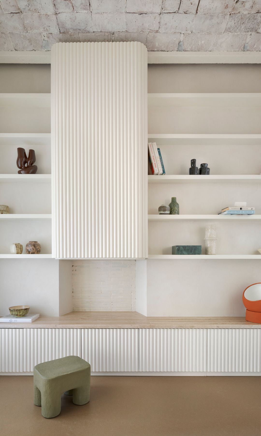 Librería acanalada con baldas de color blanco, con objetos decorativos