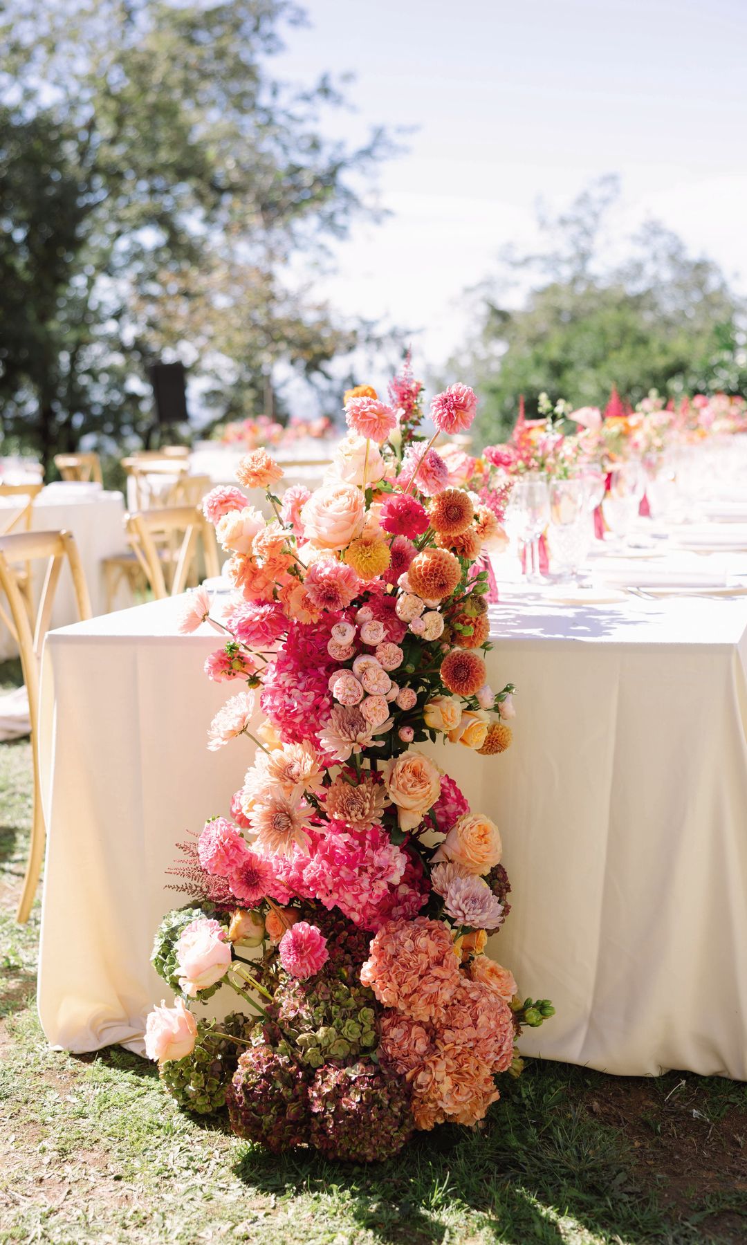 Flores en tonos rosados, naranjas y pastel como centro de mesa para el gran día