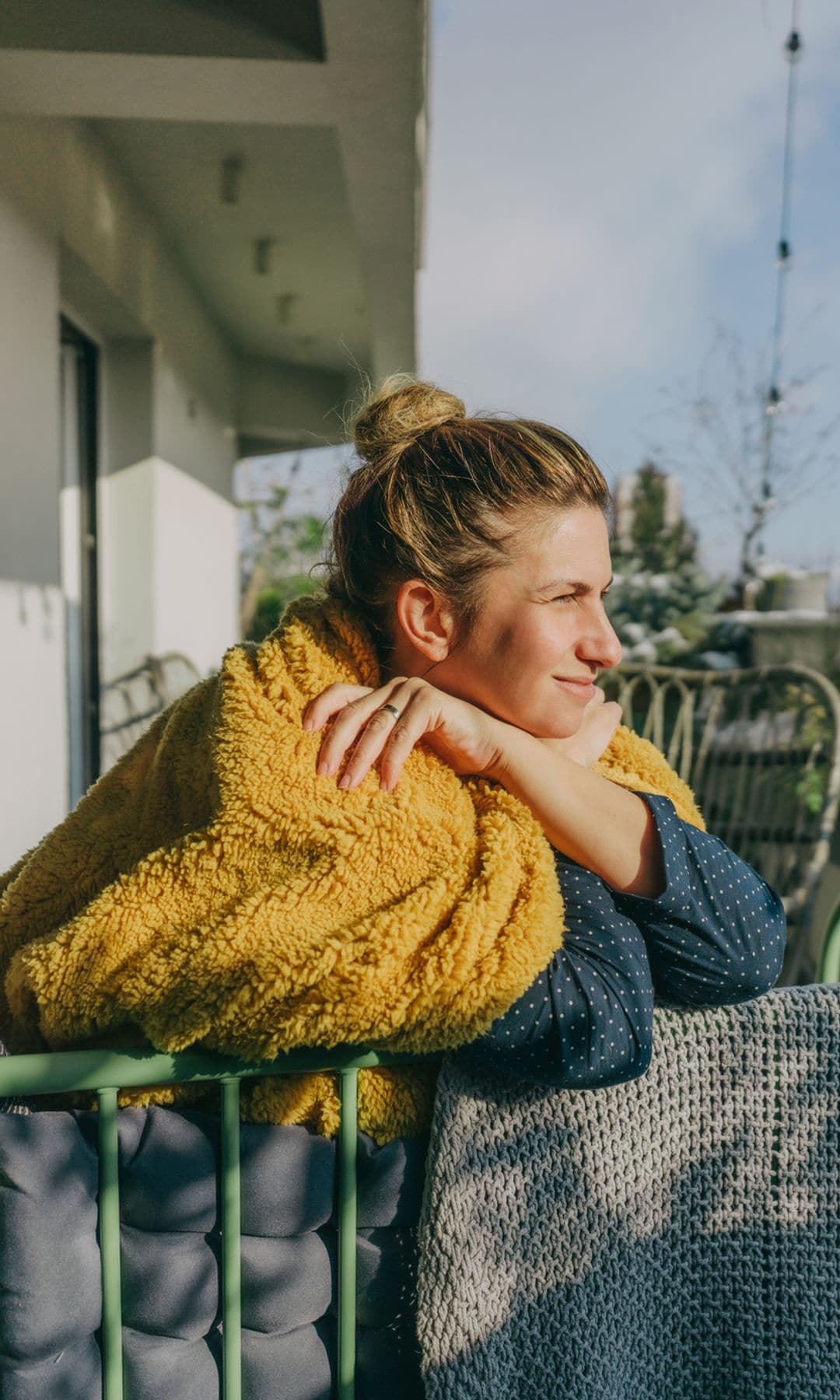 Mujer en su terraza tomando el sol antes del café para arrancar el día con energía