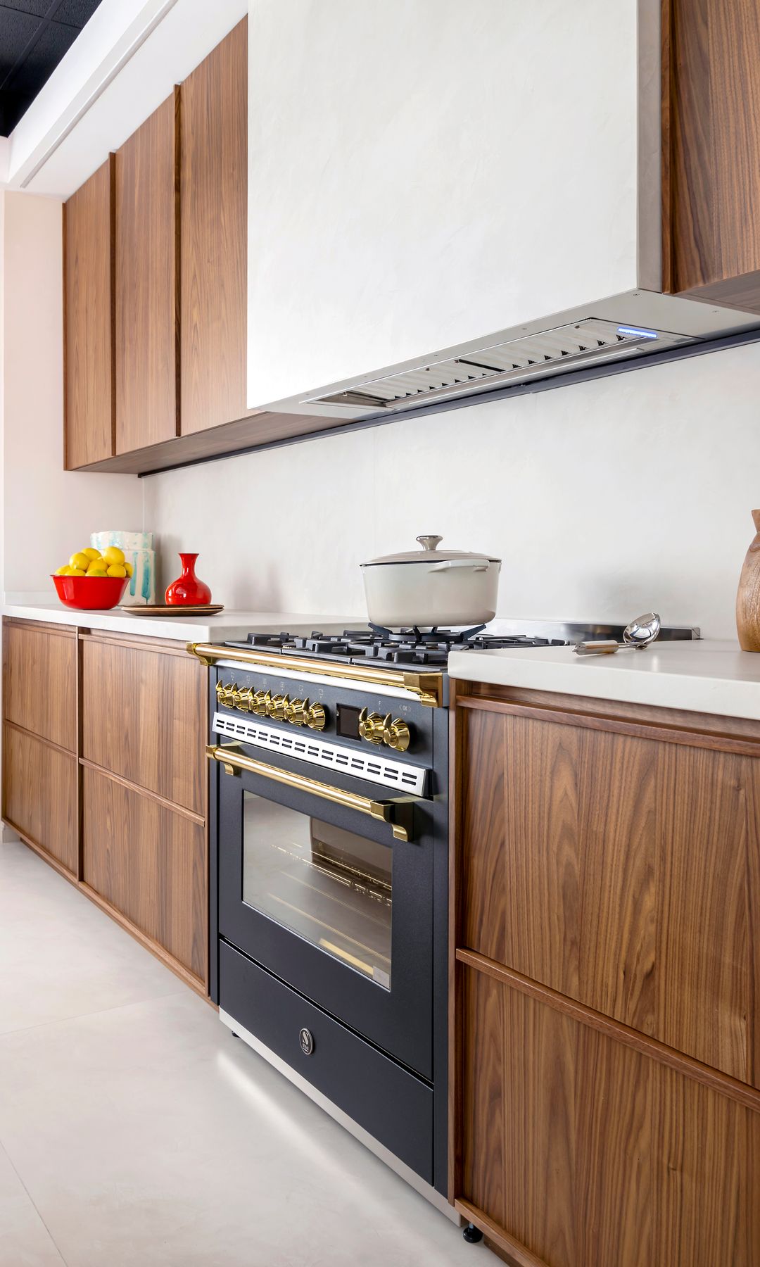 Cocina de madera con los módulos hasta el techo, cocina de fuegos negra y campana blanca