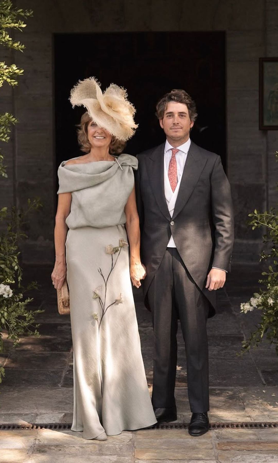 ​María, una madrina con vestido verde grisáceo con flores, de Sole Alonso, y tocado de rafia de Mimoki
