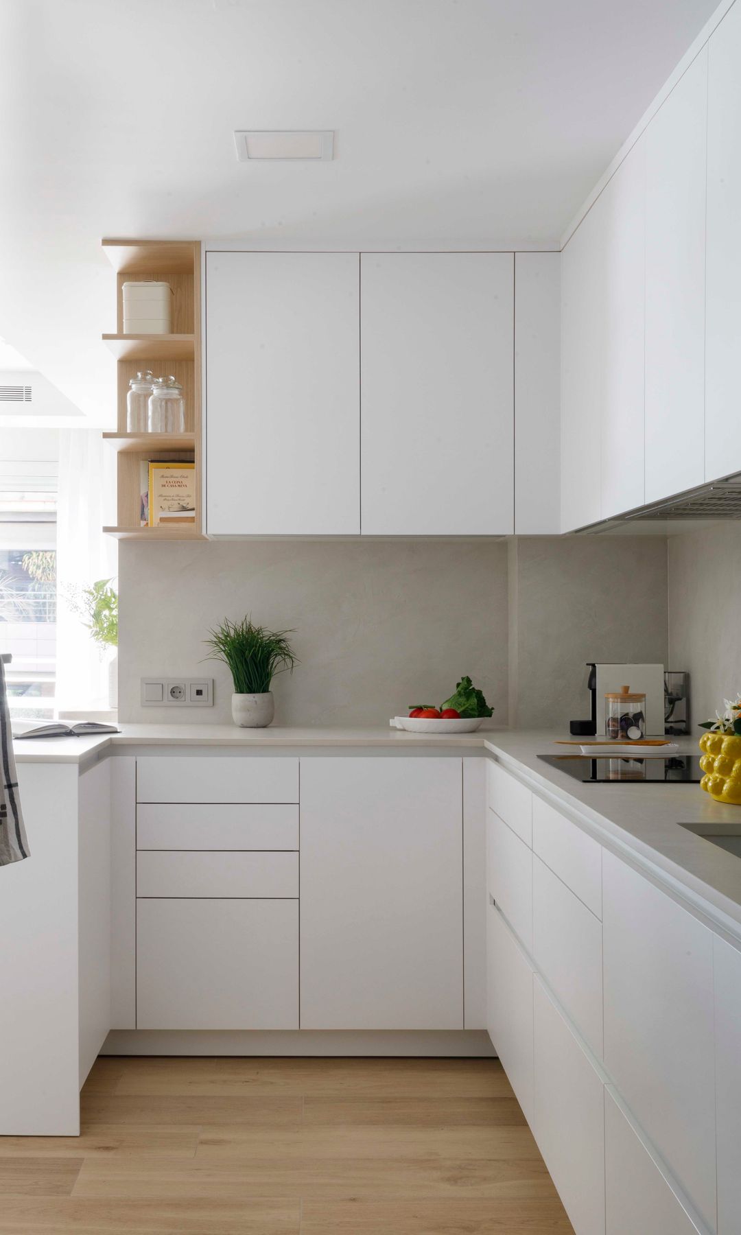 Cocina pequeña blanca con armarios hasta el techo, suelo de madera, módulo esquinero abierto 