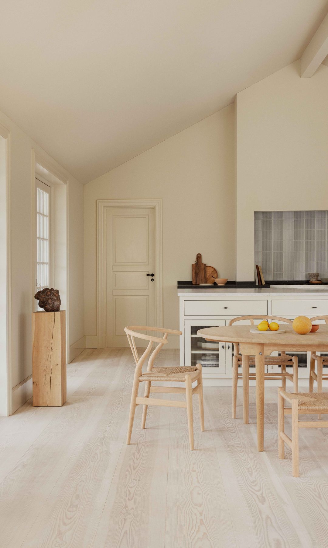 Cocina con comedor con mesa y sillas de madera, suelo de madera