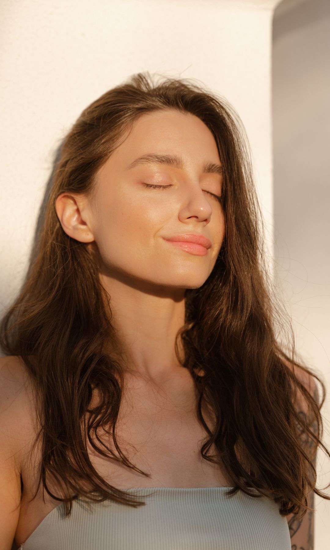 Una mujer con la cara lavada mirando al sol