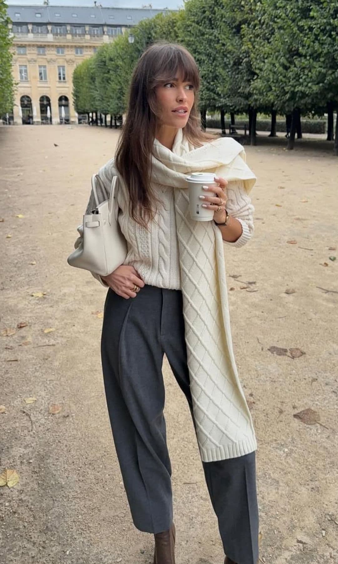 Influencer con jersey blanco y pantalones grises en París