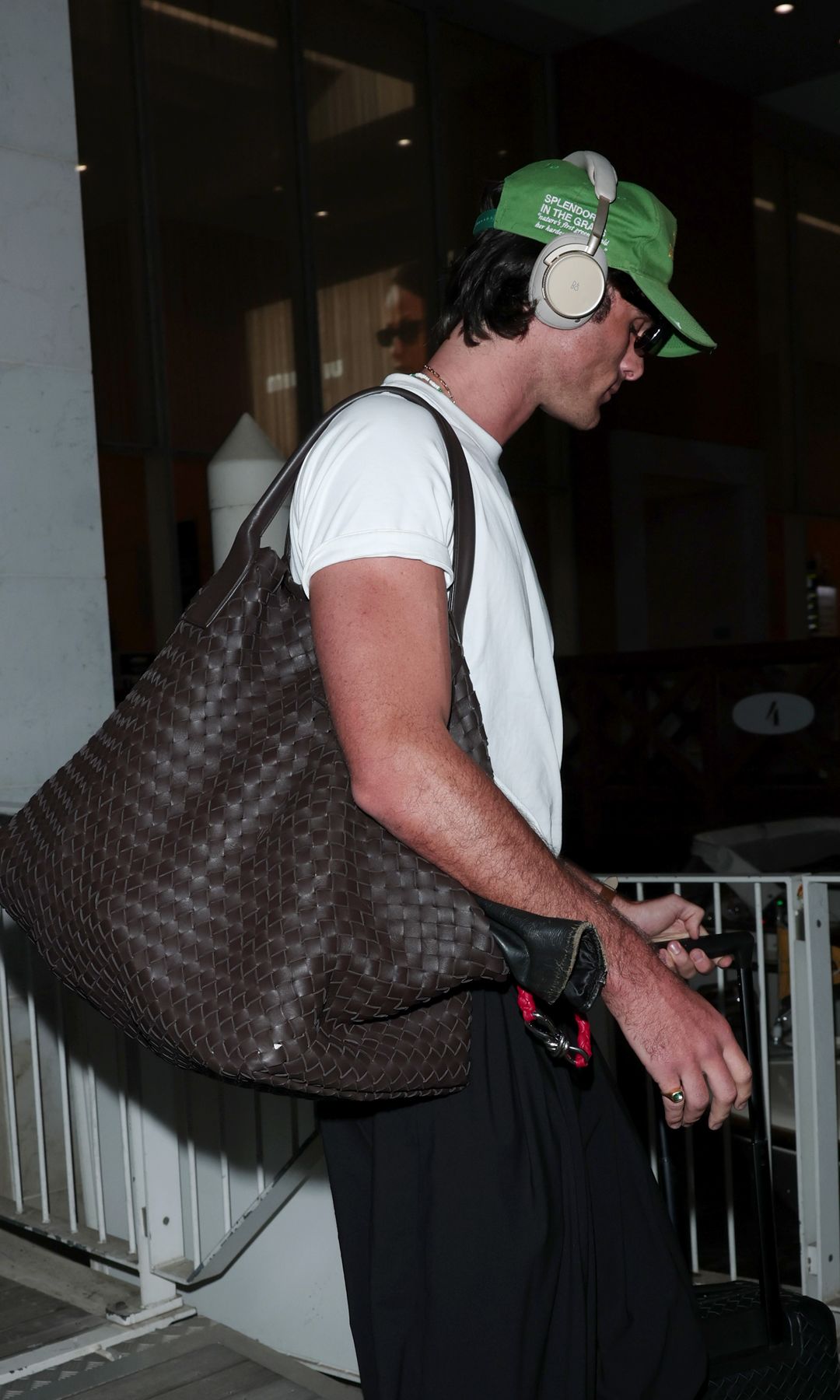 Jacob Elordi llegando al aeropuerto de Venecia, en 2025, con el bolso 'Cabat' grande de Bottega Veneta (11.000 euros)