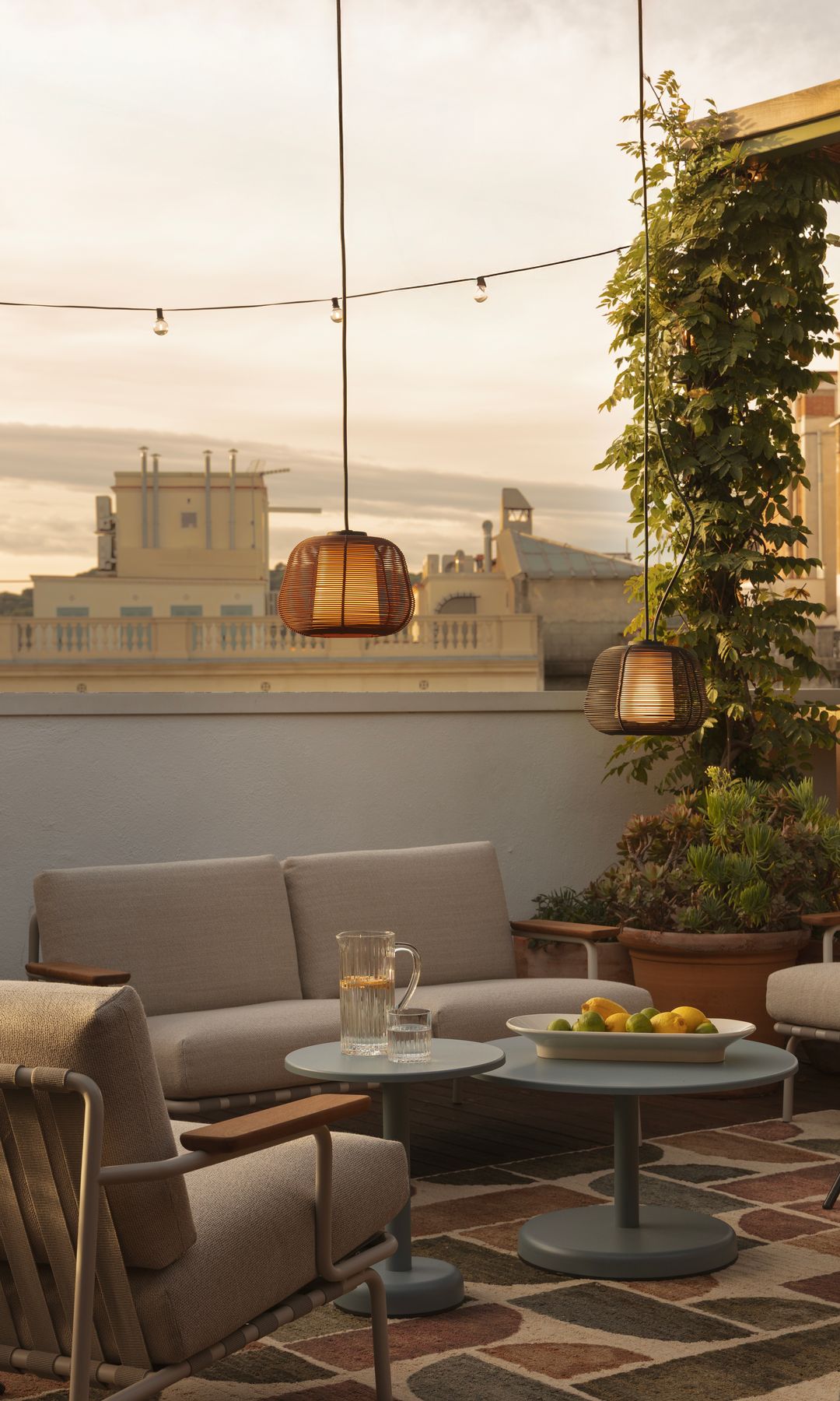 Terraza urbana con salón exterior, guirnalda de luz, lámparas colgantes de fibras vegetales 