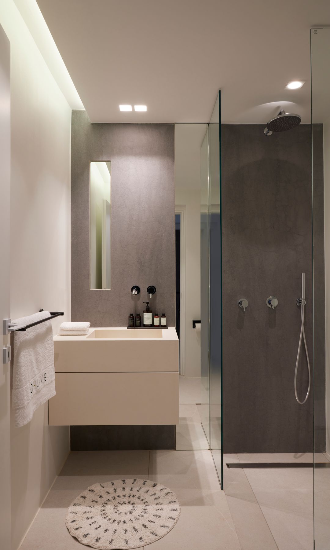 Baño con ducha a ras de suelo, mueble suspendido, alfombrilla