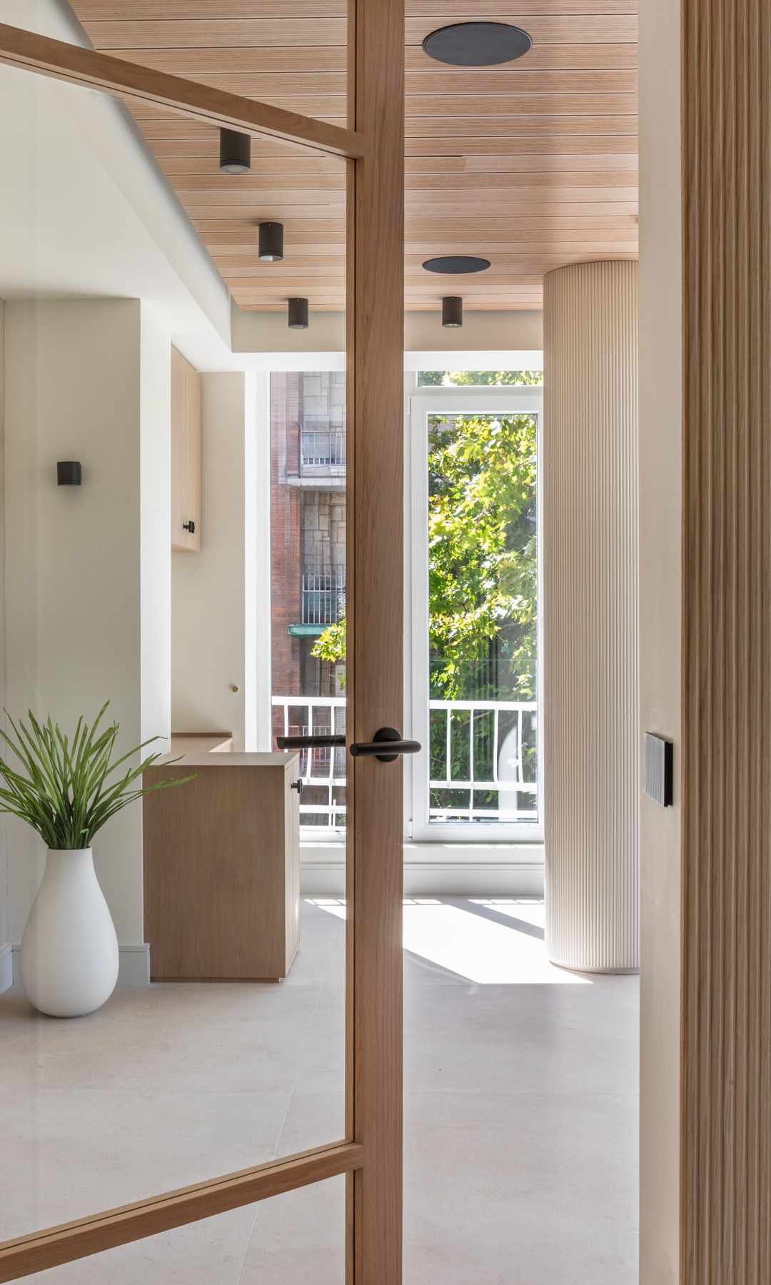 Acceso a vivienda luminosa con mezcla de materiales