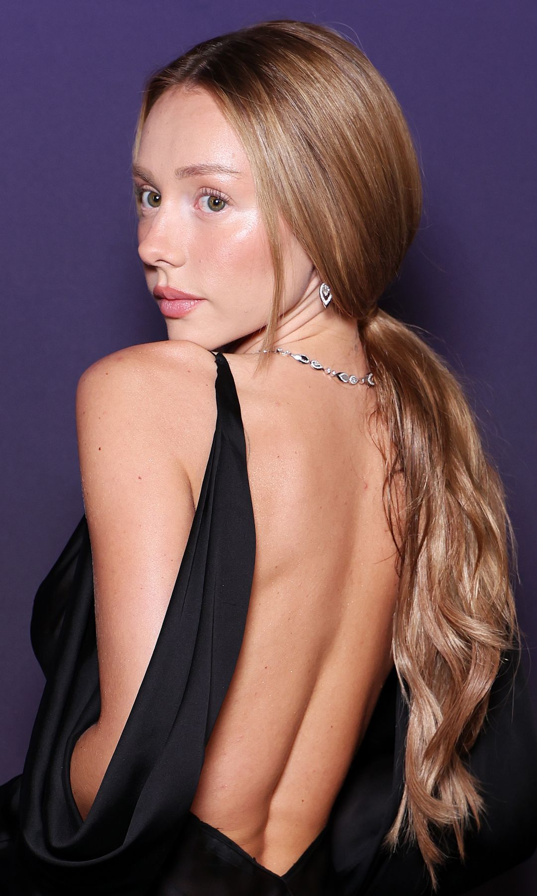 Ester Expósito en el desfile de Messika en París con vestido negro y coleta