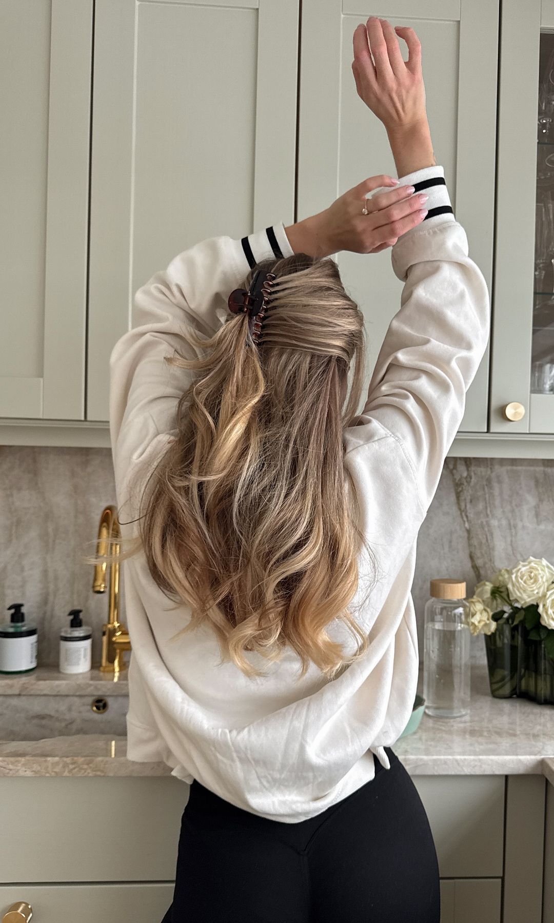 La influencer Cecilia Denise con los brazos en alto en su cocina