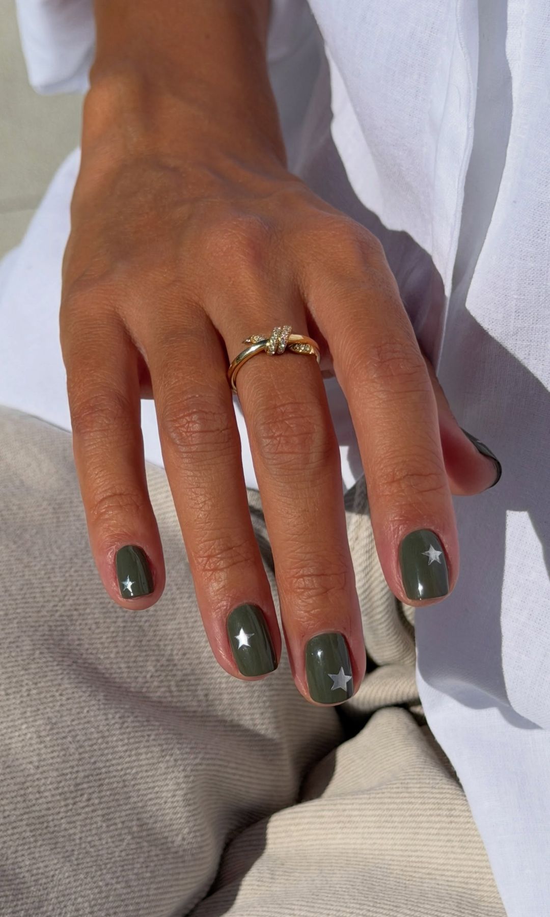Manicura verde oliva con estrellas plateada 