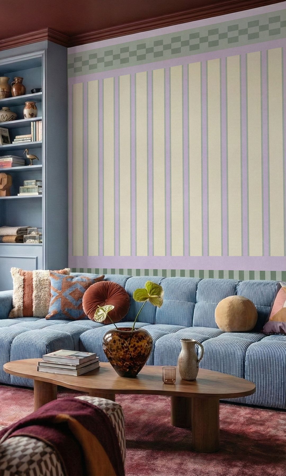 Salón con papel pintado de rayas moradas y amarillas en la pared del sofá, sofá azul con cojines, alfombra y mesa de centro de madera 
