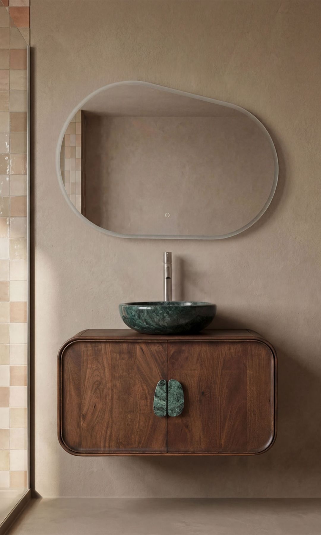 Baño con espejo de formas curvas, mueble de madera oscura con los cantos redondeados, espejo redondo de mármol