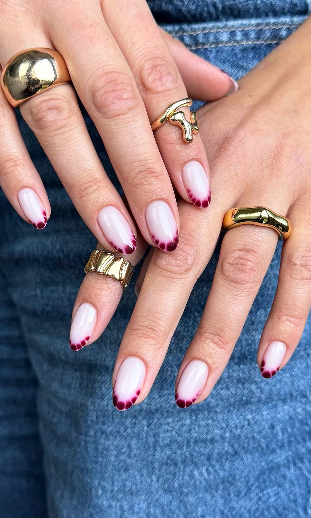Manicura francesa con manchas abstractas en color burdeos