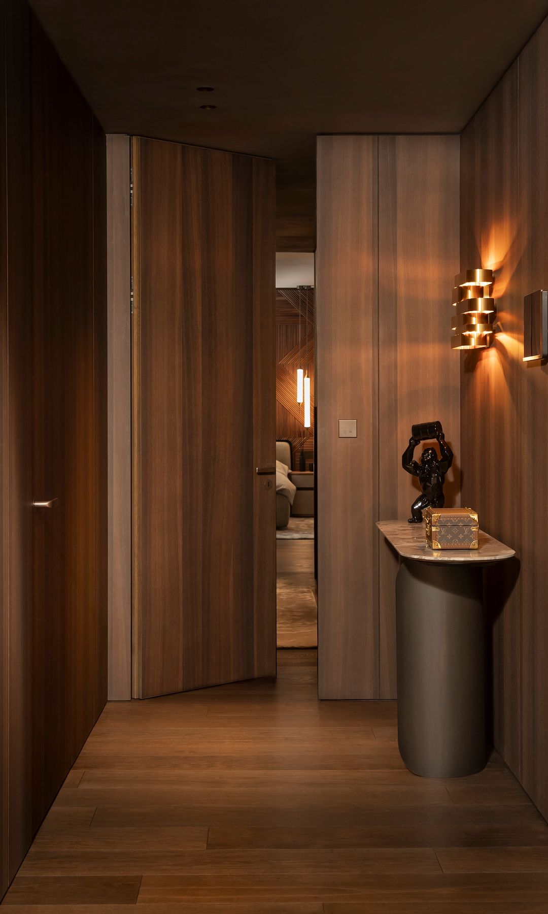 Recibidor con paredes de madera, consola y aplique de pared