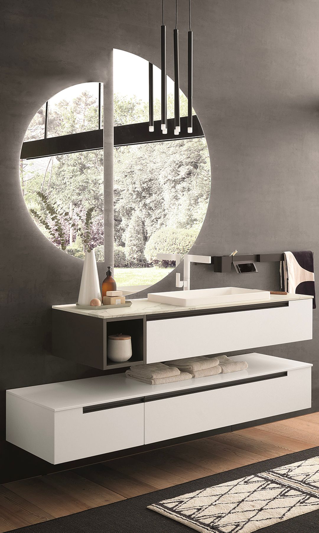 Baño con mueble bajolavabo suspendido de color blancos, espeo redondo, alfombra