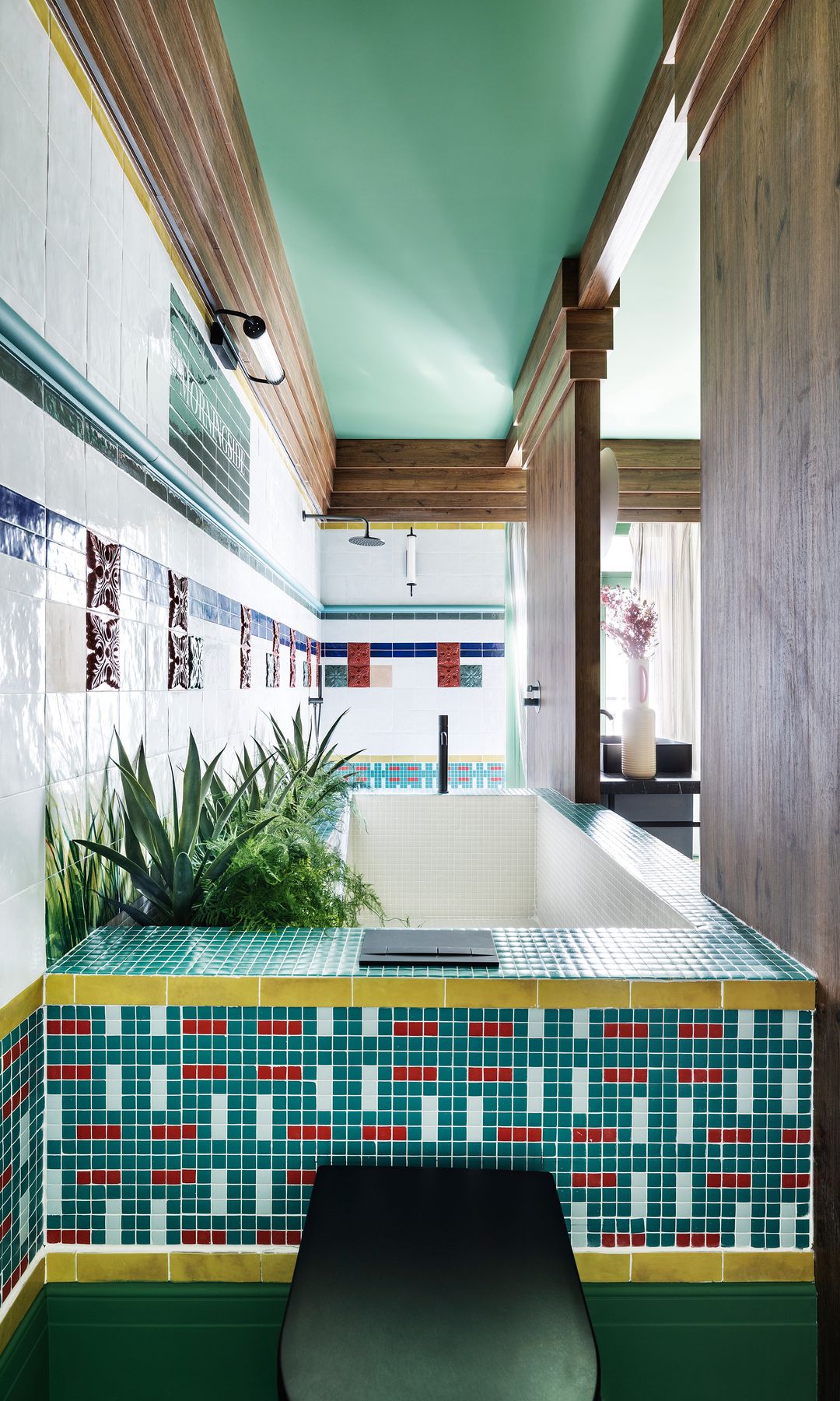 Bañera revestida con mosaico y con plantas alrededor