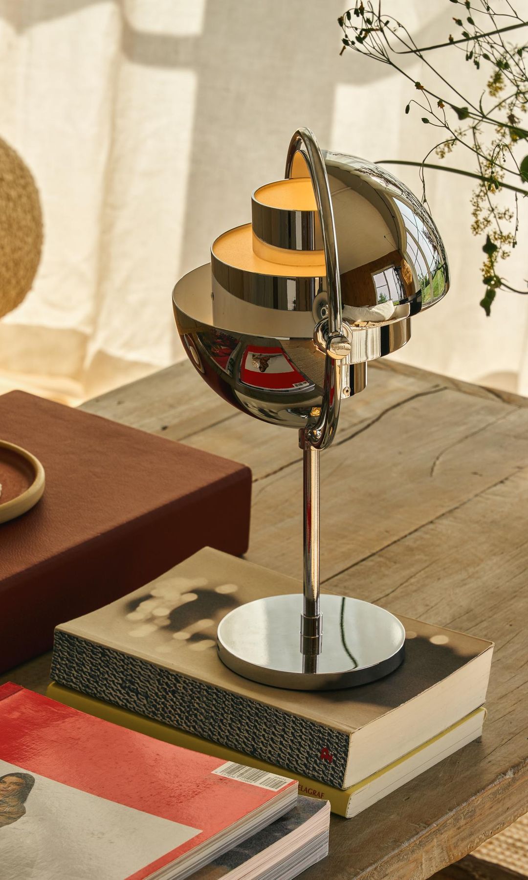 Mesa de centro de madera con libros y lámpara de sobremesa de metal