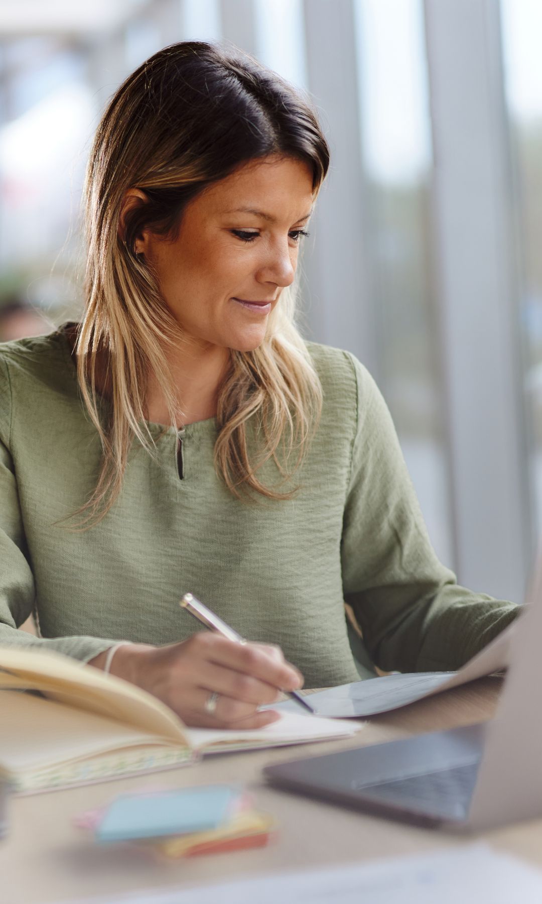 Mujer con jersey verde escribiendo