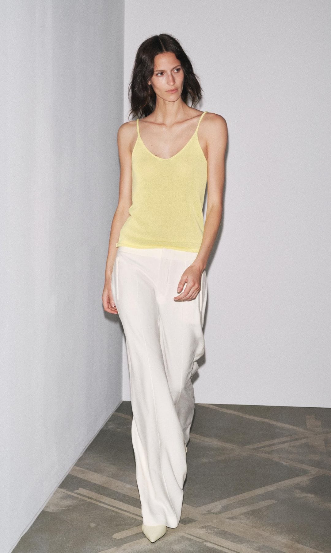 Look con top de punto amarillo básico y pantalón de traje blanco, de Zara