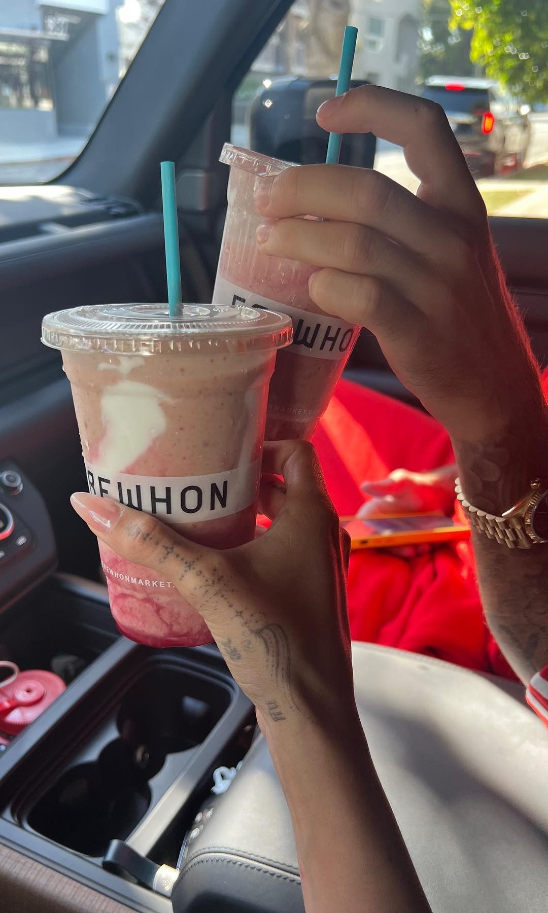 Hailey Bieber y Justin sosteniendo el batido saludable que la modelo ha creado con Erewhon