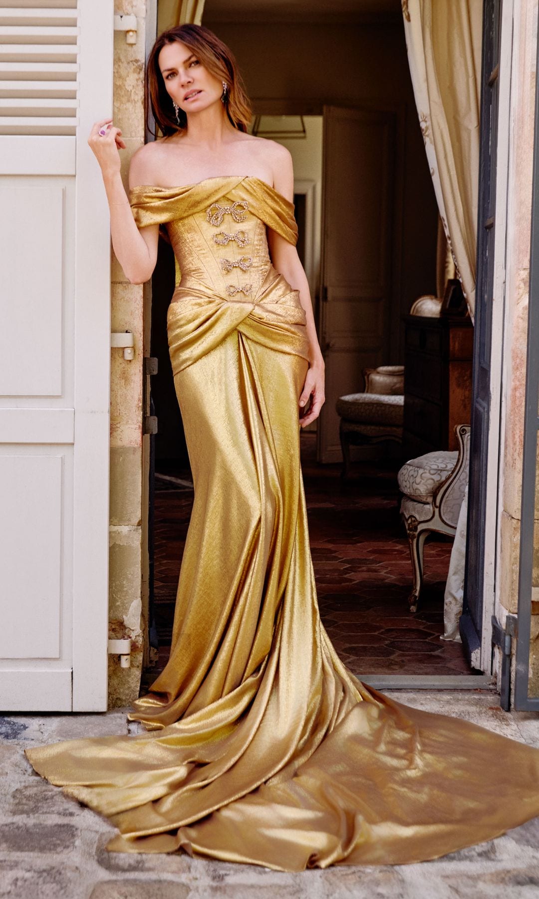 Nuestra modelo de excepción lleva, en esta sugerente imagen, vestido dorado con corsé adornado con lazos joya, y larga cola redonda, de la colección de alta costura de Elie Saab. Las joyas son de Chopard