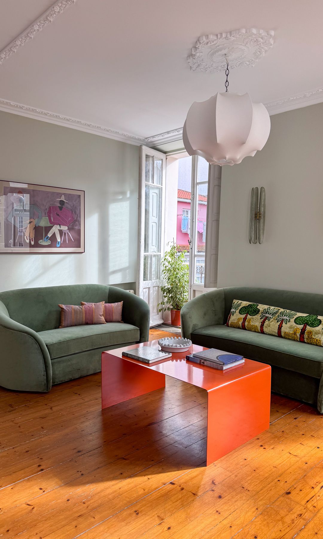 Salón con sofás curvos tapizados en verde de Be Water Home